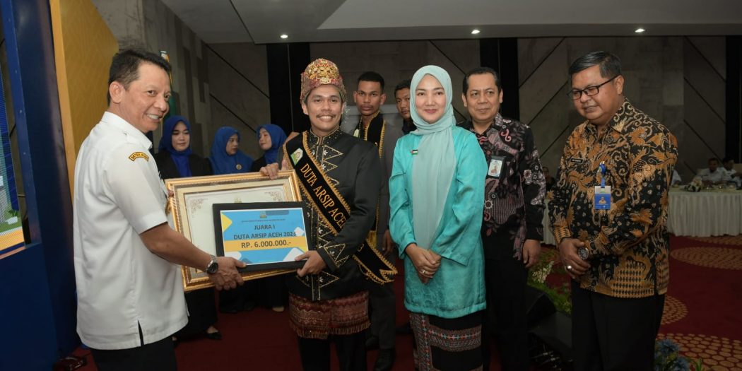 Penjabat Gubernur Aceh, Achmad Marzuki didampingi Bunda Literasi Aceh, Ny. Ayu Marzuki, saat menyerahkan piagam penghargaan kepada Duta Arsip Aceh, pada kegiatan Hari Kunjungan Perpustakaan di Gedung Perpustakaan Wilayah Aceh, Banda Aceh, Rabu (22/11/2023). (Foto: Dok. Biro Adpim Pemprov Aceh)