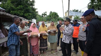 Pj Bupati Aceh Jaya menyerahkan bantuan masa panik kepada warga dalam kecamatan panga yang terdampak banjir, Kamis (23/11/2023). (Foto: Distori/Dok. Humas Aceh Jaya)