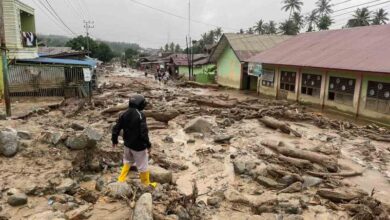 Warga berjalan di dekat bangunan sekolah yang terdampak banjir bandang di Ladang Rimba, Kabupaten Aceh Selatan. (Foto: Dok BPBD Kabupaten Aceh Selatan)