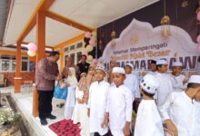 Sekda Aceh Jaya T Reza Fahlevi menyantuni anak yatim pada peringatan maulid akbar di SD N 2 Calang, Kamis (30/11/2023). (Foto: Dok. Humas Aceh Jaya)