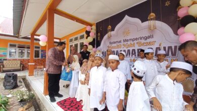 Sekda Aceh Jaya T Reza Fahlevi menyantuni anak yatim pada peringatan maulid akbar di SD N 2 Calang, Kamis (30/11/2023). (Foto: Dok. Humas Aceh Jaya)
