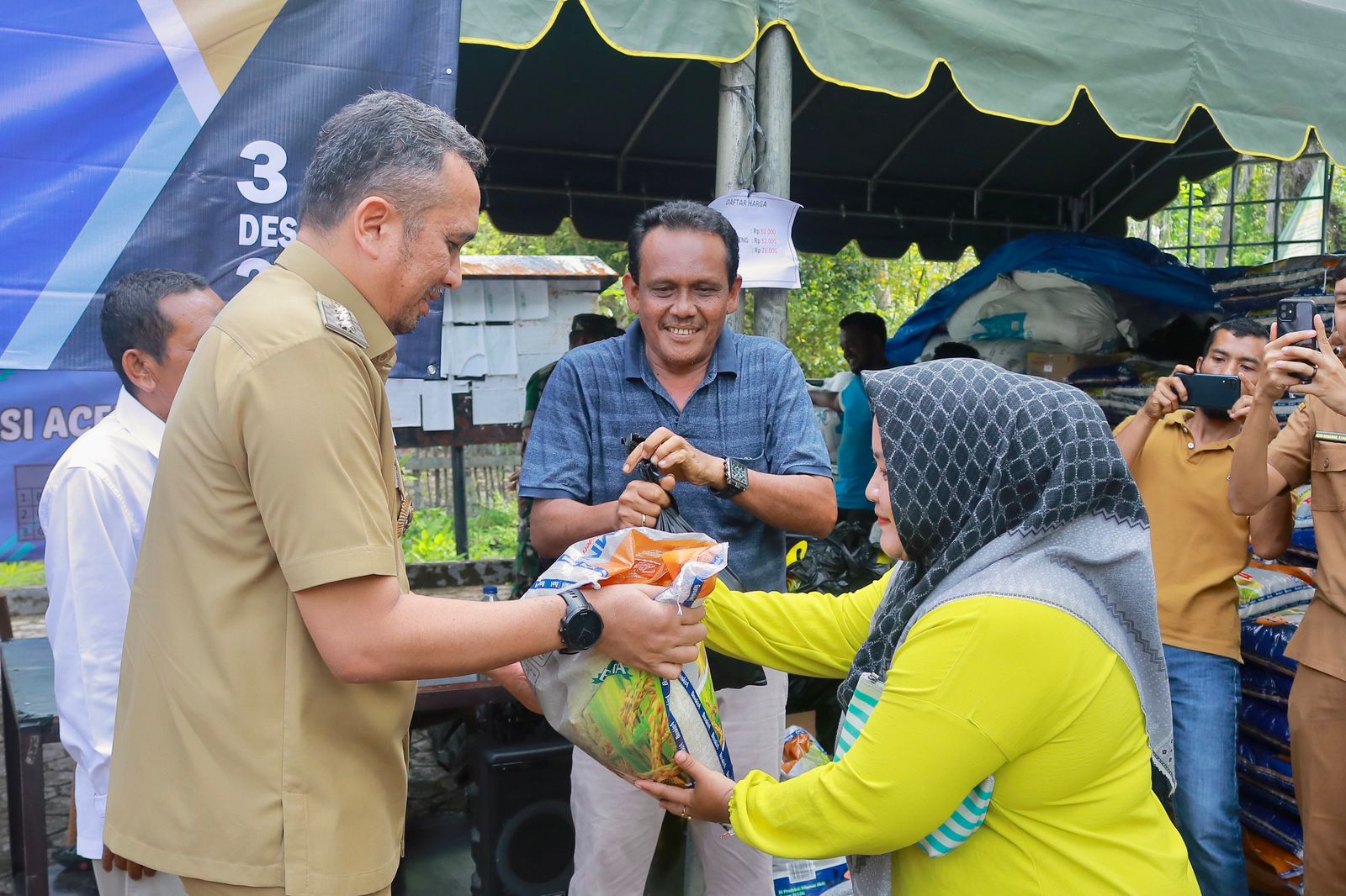 Pj Wali Kota Sabang Reza Fahlevi memberikan sembako secara seromonial kepada warga dalam acara pasar murah di Kota Sabang, Senin, (4/12/2023). (Foto: Dok. Pemko Sabang)