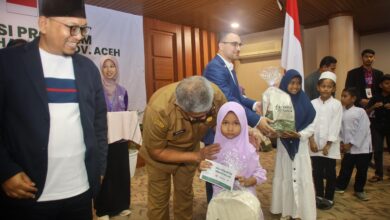 Sekda Aceh, menyerahkan beasiswa kepada anak yatim pada kegiatan implementasi program beasiswa yatim tahap IV Provinsi Aceh, kerjasama RQV dengan Hayrat Yardim Indonesia di Aula Serbaguna Setda Aceh, Senin, (4/12/2023). (Foto: Dok. Adpim Pemprov Aceh