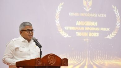 Sekda Aceh, Bustami menyerahkan penghargaan kepada pemenang Anugerah Keterbukaan Informasi Publik Tahun 2023 yang diselenggarakan Komisi Informasi Aceh di Aula Amel Convention Hall, Banda Aceh, Rabu, (6/12/2023). (Foto: Dok. Adpim Pemprov Aceh)