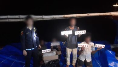 Pelaku penyelundupan memperlihatkan rokok ilegal usai ditangkap tim gabungan Bea Cukai di perairan Aceh. (Foto: Humas bea cukai Aceh)